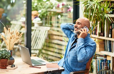 Happy man working from home office and talking on the phone