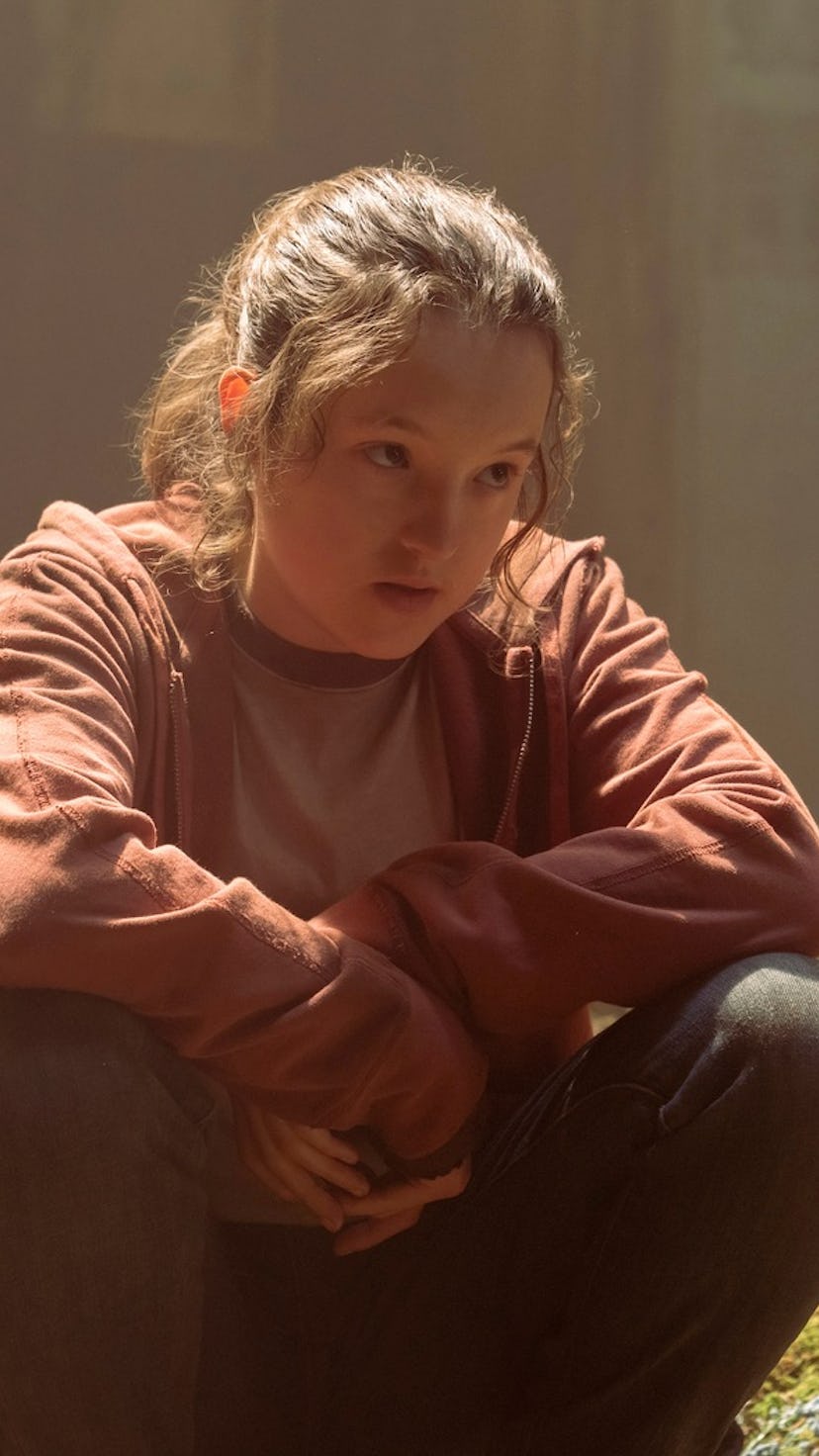 Bella Ramsey as Ellie in The Last of Us, sitting in a sad building 