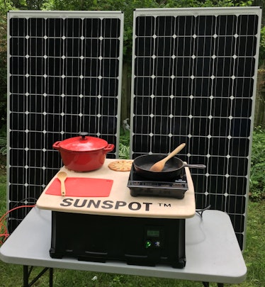 An image of the SUNSPOT induction cooker, battery, and solar panels.