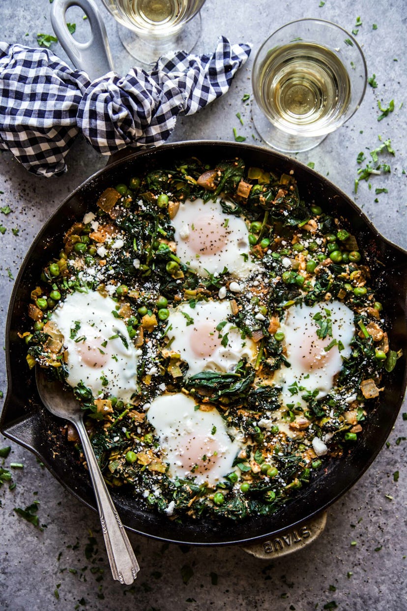 cast iron pan with green shakshuka on a table spring recipe