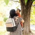 woman wearing backpack while holding toddler