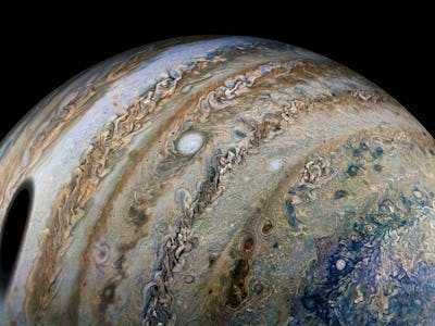 The icy moon Ganymede creates a round shadow over Jupiter's cloud tops. NASA's Juno spacecraft took ...