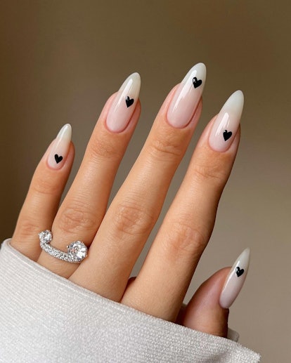 If you're going on a vacation and need an idea for your nails, a milky white manicure with black hea...