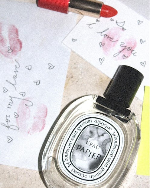 Diptyque Eau Papier fragrance next to lipstick