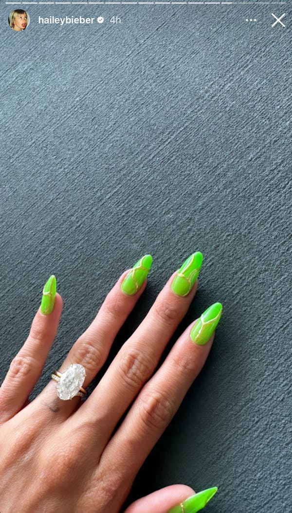 Hailey Bieber's 2023 Coachella nails have neon green, glow-in-the-dark nail polish with a gold desig...