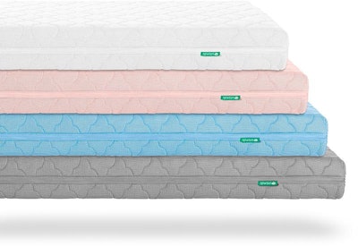 Four grey, blue, pink, and white crib mattresses on top of each other