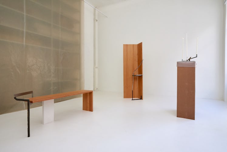 minimalist wooden furniture in a white gallery space