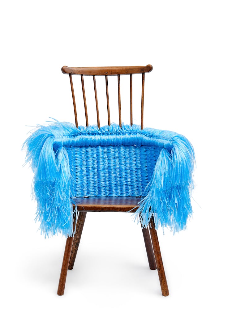 a wooden stick chair wrapped in shiny blue twine