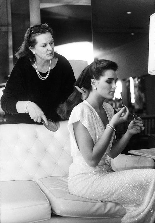 Actress Brooke Shields applies makeup while her mother, Teri, brushes her hair, 1984.