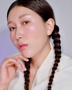 woman with glowing skin and brown hair in pigtails