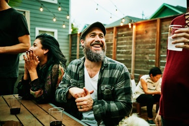 Happy, likable man talking with friends outside