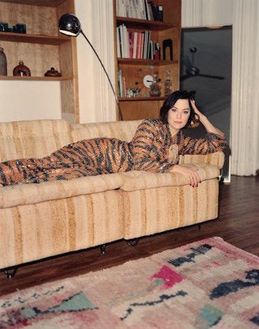 بازیگر پارکر پوزی با لباسی راه راه ببری روی کاناپه دراز کشیده است