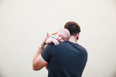 Man burping baby on shoulder