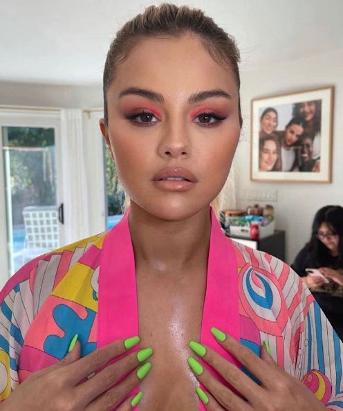 Selena Gomez neon green nails with hot pink eye makeup and rainbow robe