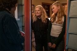 Nico Hiraga as Seth, Amy Poehler as Lisa, Hadley Robinson as Vivian stand in a doorway in 'Moxie,' a...
