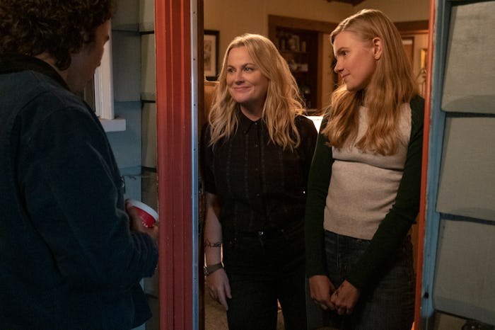 Nico Hiraga as Seth, Amy Poehler as Lisa, Hadley Robinson as Vivian stand in a doorway in 'Moxie,' a...