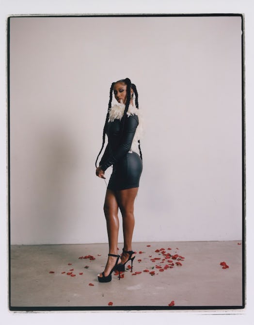 A model wears a feathered black mini dress by Tia Adeola.
