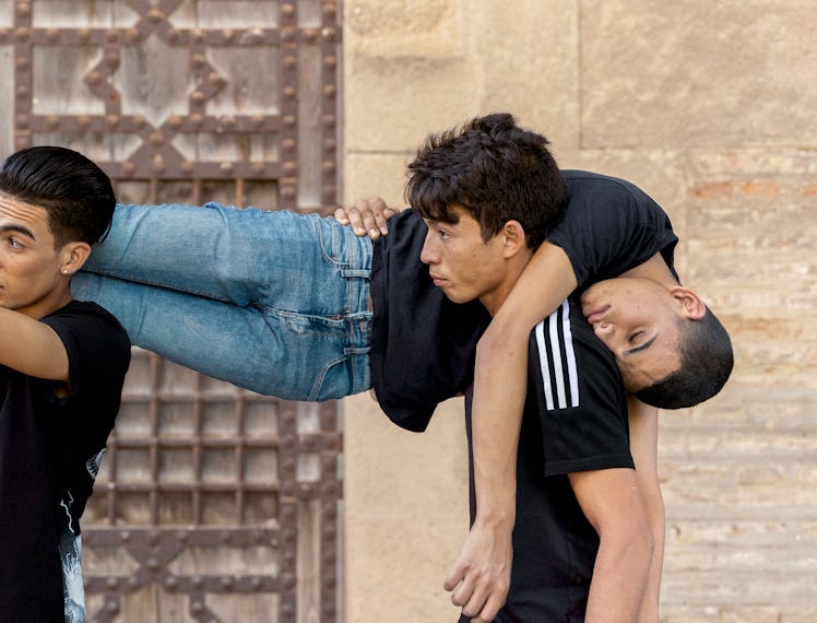 Bilal’s body is carried by his friends after a fainting episode. Photograph from Felipe Romero Beltr...