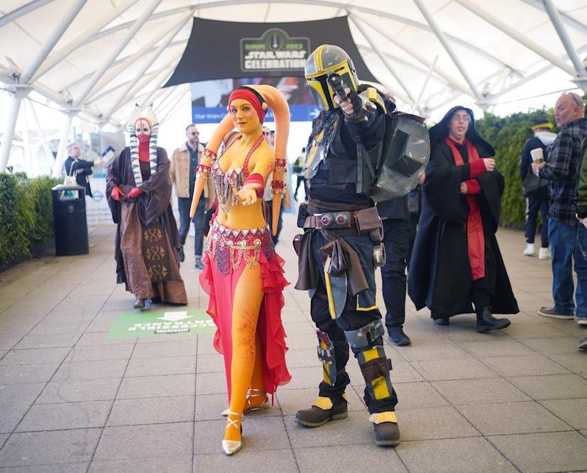 Fans in costumes including a Twilek and a Mandalorian at Star Wars Celebration.
