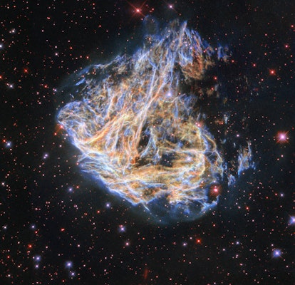Shreds of the colorful supernova remnant DEM L 190 seem to billow across the screen in this image fr...