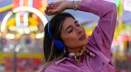 Young woman listening to music as Mercury and Pluto retrograde in May 2023.