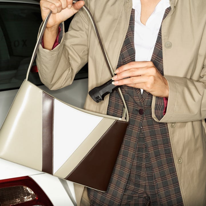 A woman puts an anti-assault pocket mace device, or pepper spray, in her purse.