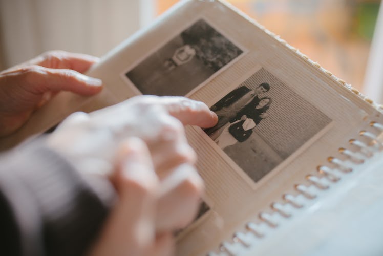 Couple pointing to old black and white picture of family member