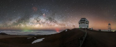 an observatory on a hilltop with the zodiacal lights in the background