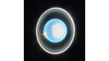 Uranus — seen from pole-on so the rings around it are visible, with a white splotch on the pole and ...