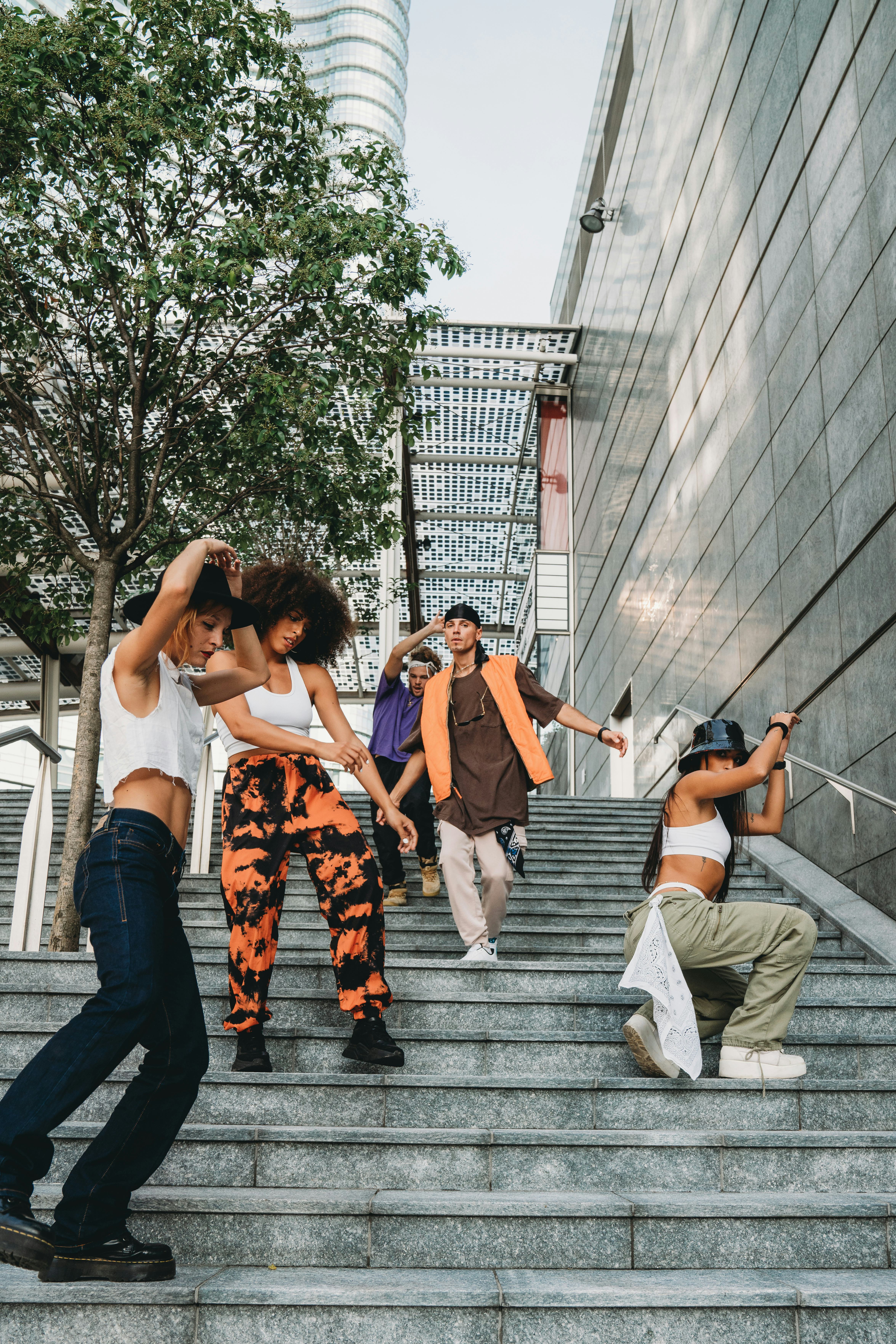 Five young friends moving smoothly down a staircase as the best-dancing zodiac signs.