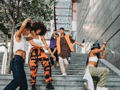 Five young friends moving smoothly down a staircase as the best-dancing zodiac signs.