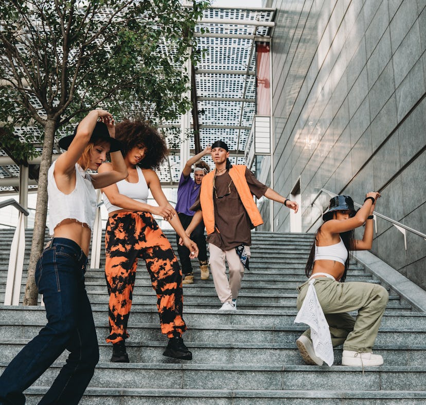 Five young friends moving smoothly down a staircase as the best-dancing zodiac signs.