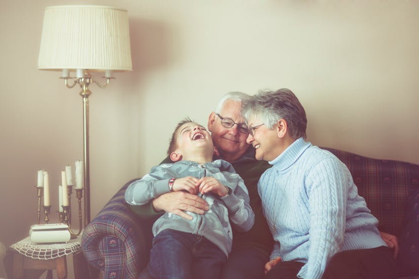 Grandma and grandpa playing with grandson and laughing