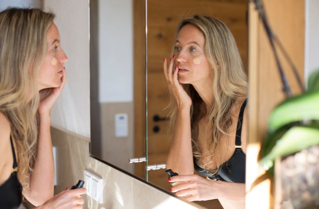 A woman applies light foundation