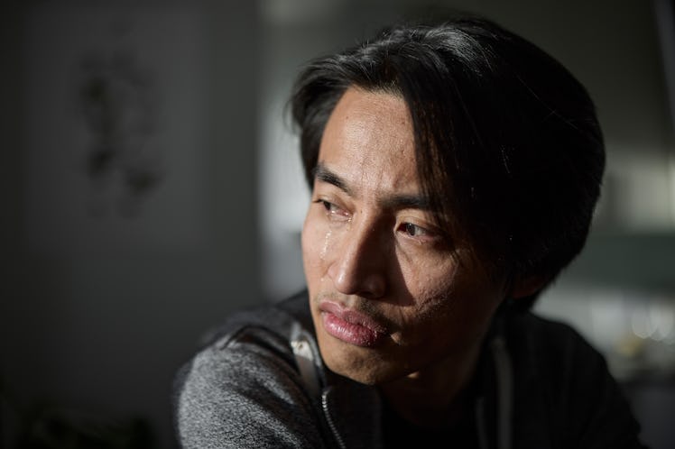 A man crying, looking away.