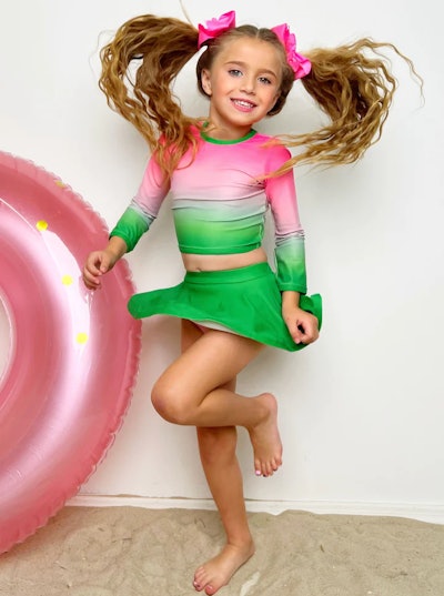 Kids swimsuit in pink a green, a two-piece set with long sleeve rash guard and skort bottoms