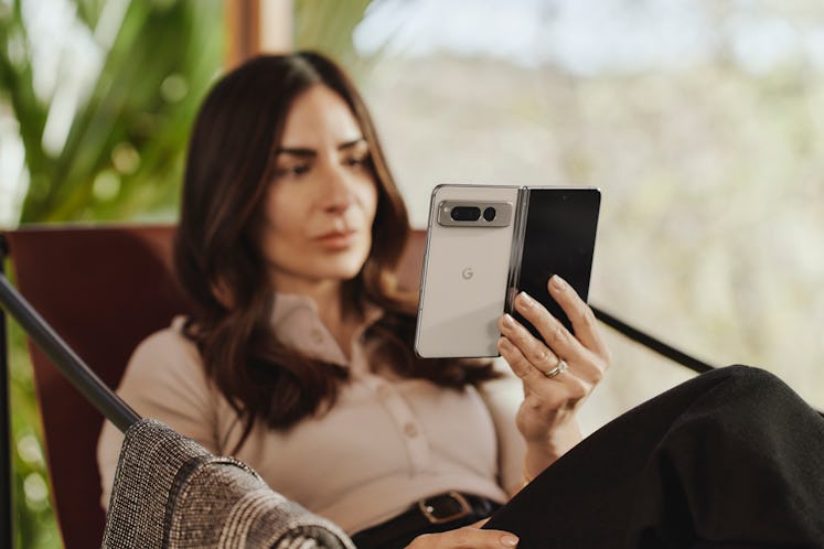 A woman holding the Google Pixel Fold in a book orientation.
