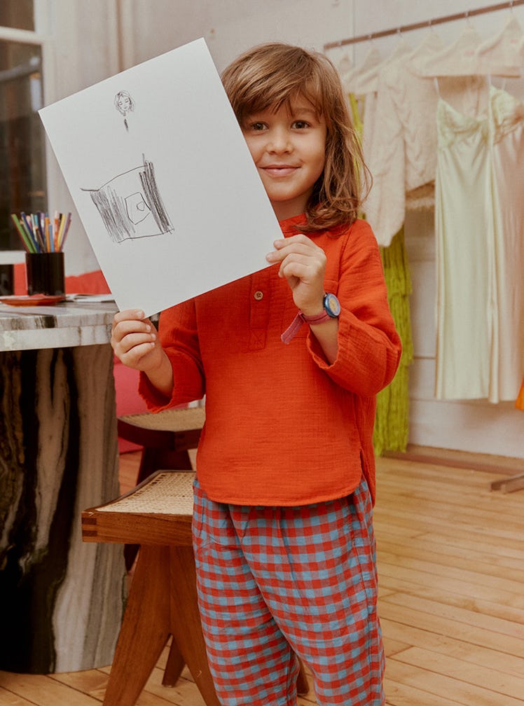 Designer Alejandra Alonso Rojas's son Alonso holds up a drawing in his mother's design studio.