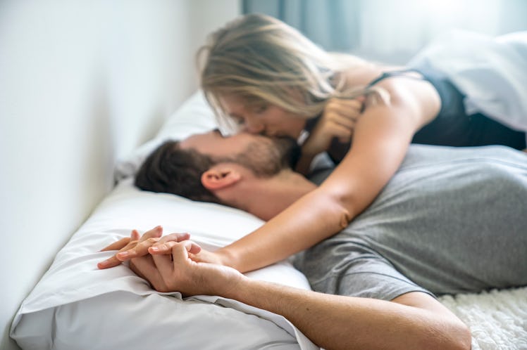 Man and woman kissing in bed