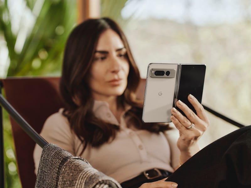 A woman holding an unfolded Google Pixel Fold in a book-like orientation