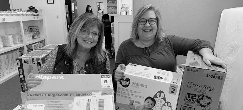 two women at a diaper bank, in an round up of charities to give to for Mother's Day