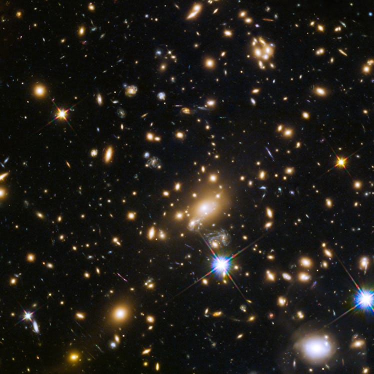 image of a field of white, blue, yellow, and orange stars and galaxies in space