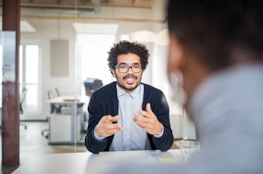 Young man in office negotiating with someone across from him