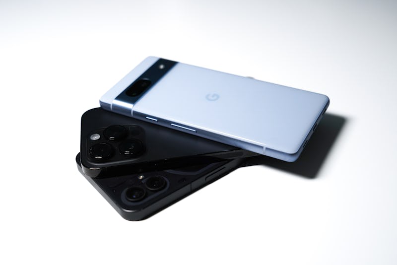 The blue Pixel 7a sitting on some iPhones.