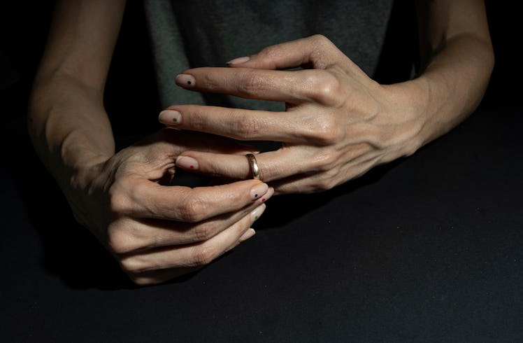 Close up of man's hands as he removes wedding ring