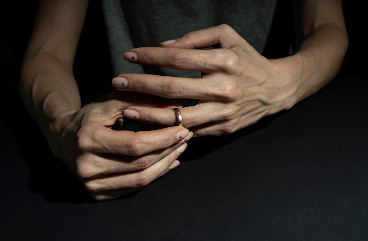Close up of man's hands as he removes wedding ring