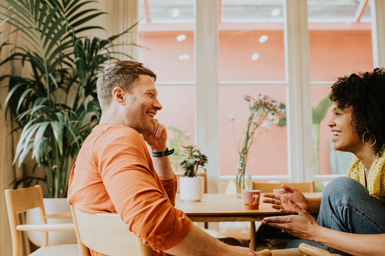 Charming man having conversation with friend in cafe