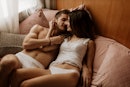 一个男人和一个女人穿着内衣躺在床上，准备接吻。