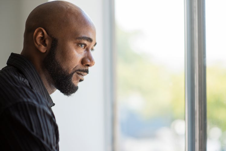Middle aged man with bald head looking pensive and sad