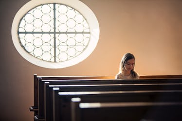 A child sitting alone in a church pew.